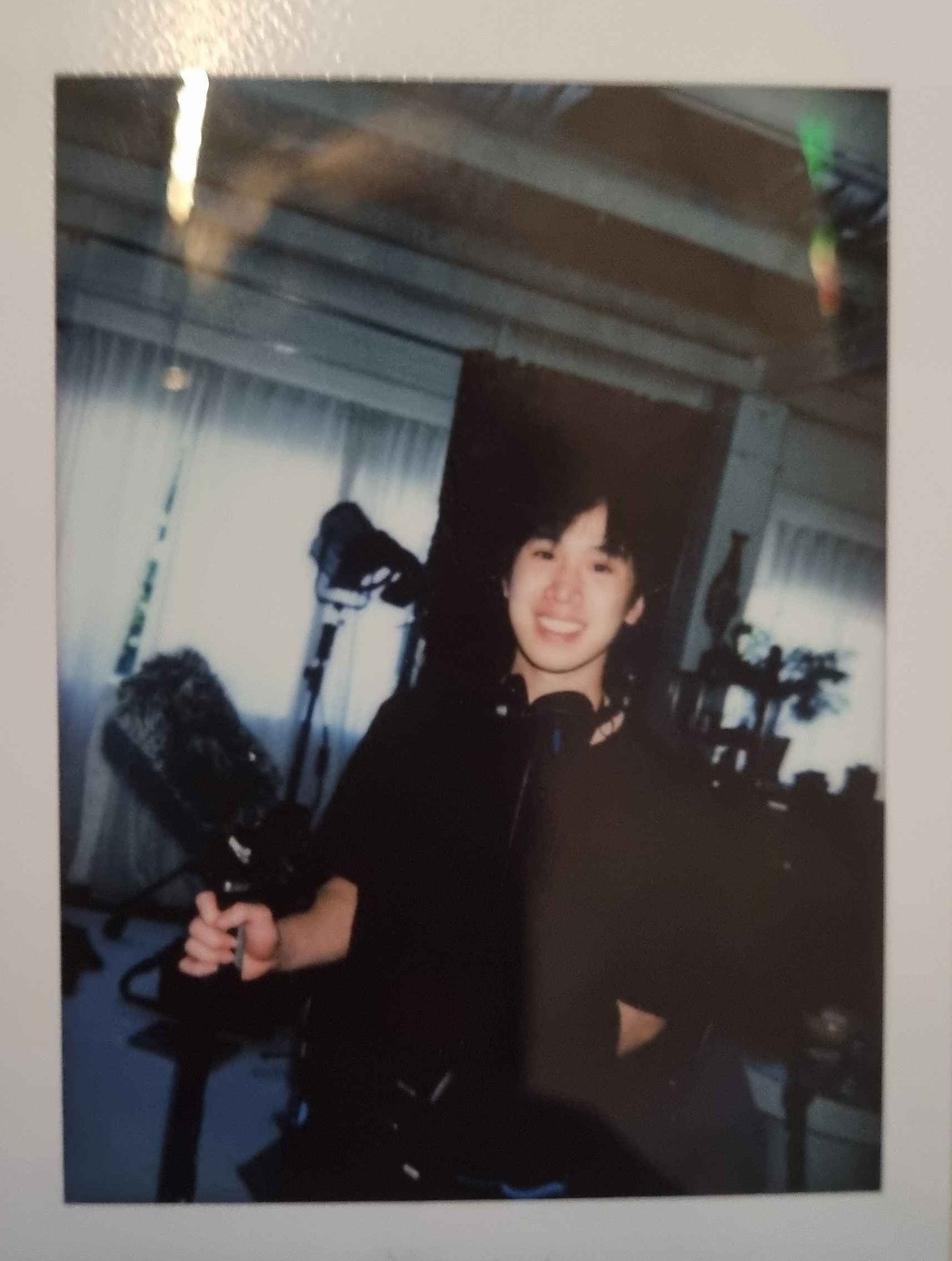 Polaroid photo of Collins Nguyen on set holding recording equipment